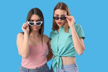 Female friends in sunglasses on blue background