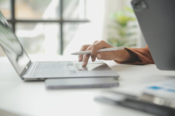 Entrepreneur Asian businessman and businesswoman discussing new business project in tablet in modern Meeting In Modern Office, Asian business casual concept.