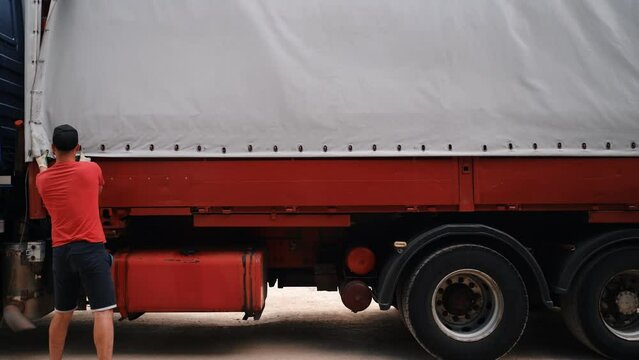 truck for transportation. Men unload a sheet of hardboard