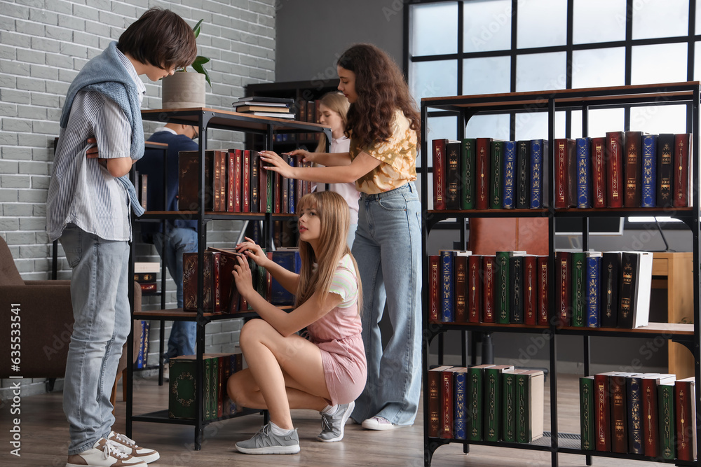 Canvas Prints group of students taking books from shelves in library