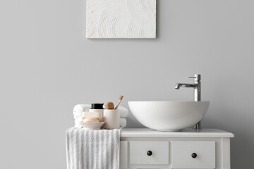 Fototapeta na wymiar Sink bowl and bath accessories on table in light bathroom