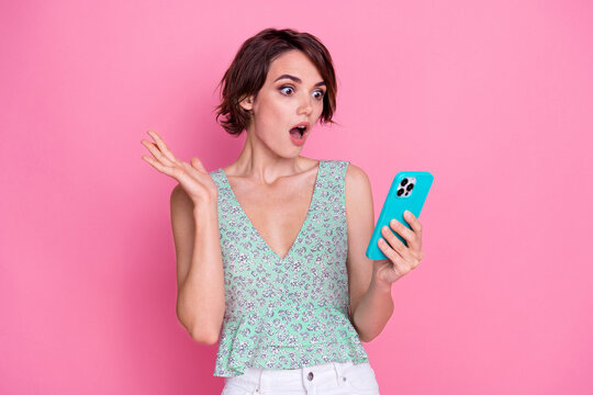 Portrait of crazy young lady cyan top holding smartphone modern device shock oops miss clicked website isolated on pink color background