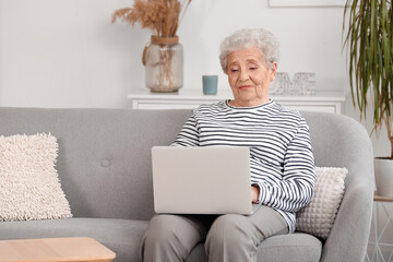 Senior woman using laptop at home