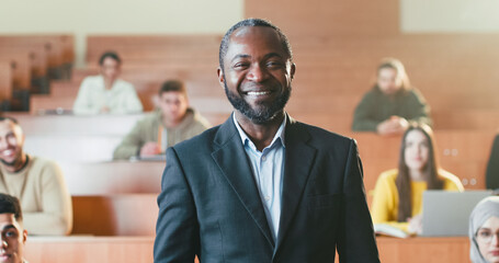 African American male cheerful professor taking selfie photo with smartphone among multiethnic...