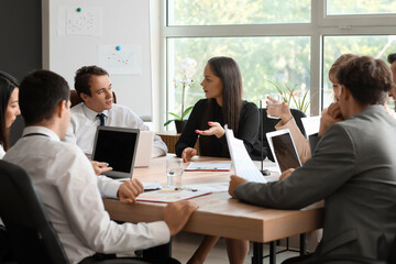 Group of business consultants working at table in office
