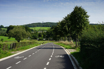 Dutch regional road with very well marked bicycle lanes. Located in the Dutch province Limburg near Vaals and Holset with the "drielandenpunt" in the distance.