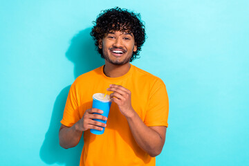 Portrait of cheerful person toothy smile hands hold plastic soda drink cup straw empty space isolated on turquoise color background