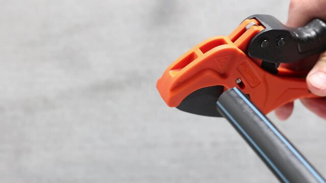 Cutting HDPE pipe with cutter scissors for cut plastic pipes.