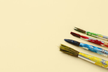 Obraz premium Artist's brushes with paints on beige background