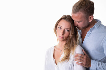 couple body language reflecting a strained and distant connection, while he stand behind her with his nose dig in her hair marked expressions by frustration and visible tension in a difficult phase