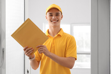 Young courier with envelope at doorway