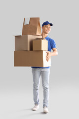 Young courier with parcels on light background