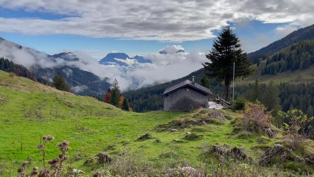 Lonely house in Austria mountains  over cloudy sky. Natural landscape with cabin on countryside
