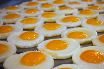 Prepare a breakfast. many fried egg on a food tray.