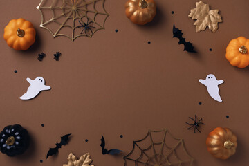 Halloween party decorations from pumpkins, bats, spider web and ghosts top view. Happy halloween holiday greeting card flat lay style..
