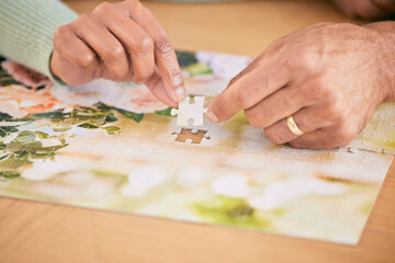 Fototapeta na wymiar Puzzle on table, piece and hands of couple in home for bonding, fun activity and relax together. Retirement, marriage and closeup of people with jigsaw for playing games, hobby and entertainment