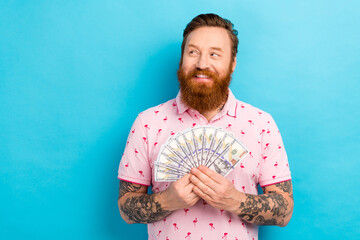Portrait of good mood man with cool tattoo wear flamingo t-shirt holding money look at offer empty...