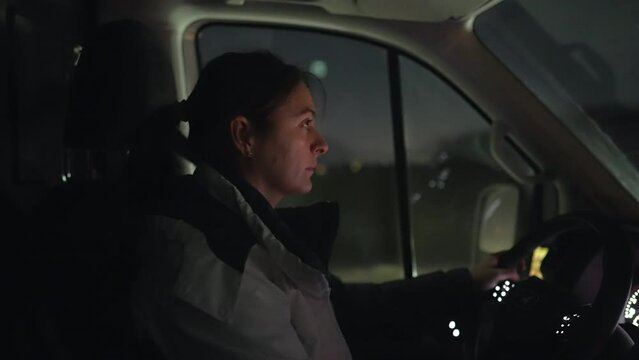 Woman driving truck at night, female driver concentrated on road in the evening - eyes on highway, person relocating to new home driving moving vehicle