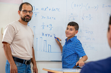 Arabian Children's in school so excited with their teacher and raising their hands to answer the...
