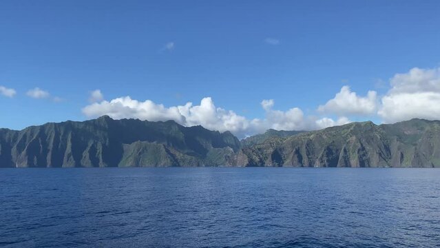 Video of islands in French Polynesia and white clouds in a blue sky from a boat