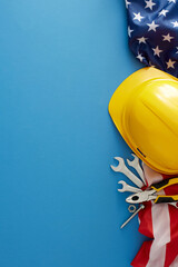 Embrace the American national holiday: Labor Day. Top view vertical shot of american flag, safety helmet, tools on blue background with empty space for advert or text - obrazy, fototapety, plakaty