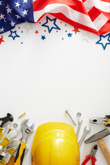 Create your custom happy Labor Day banner. Top view vertical shot of USA flag, yellow helmet,  tools, stars confetti on white background with empty space for advert or text