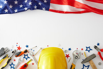 Labor Day festivities idea. Top view arrangement of american flag, yellow hard hat, worker tools, patriotic confetti on white background with empty space for promo or text - obrazy, fototapety, plakaty