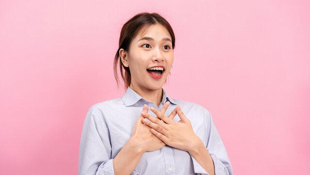 Young asian woman use both hands touching on the chest and open mouth while feeling shocked and scared