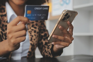 Women holding credit card and using smartphones at home.Online shopping, internet banking, store online, payment, spending money, e-commerce payment at the store, credit card, concept