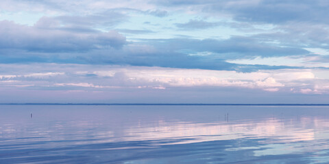 Nature picturesque landscape, clouds reflected on water surface, windless summer weather, purple blue trend sky background, mirroring sky on water, white blue nature gradient, aesthetic banner