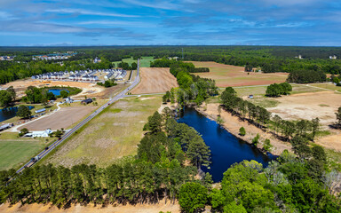 Aerial drone acres of brownfields. Landscape beauty of nature harvest farms. Top view from above pond and fields.