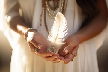 Foto op Plexiglas Woman with boho jewellery holding a feather in her hands close up © Jasmina
