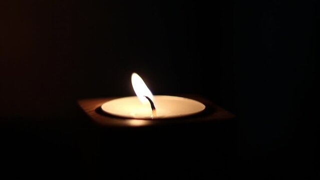 Close-up of flame burning on the candle isolated on a black background. Lighting wick with lighter