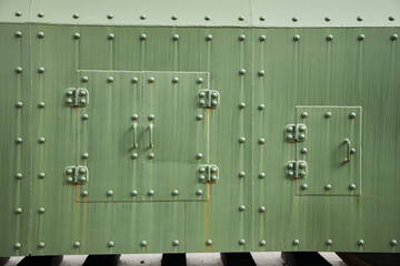 The texture of the metal surface is green with rivets. Military technics
