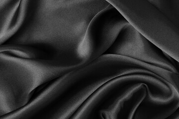 Black fabric texture background, wavy fabric slippery black color, luxury satin cloth texture.