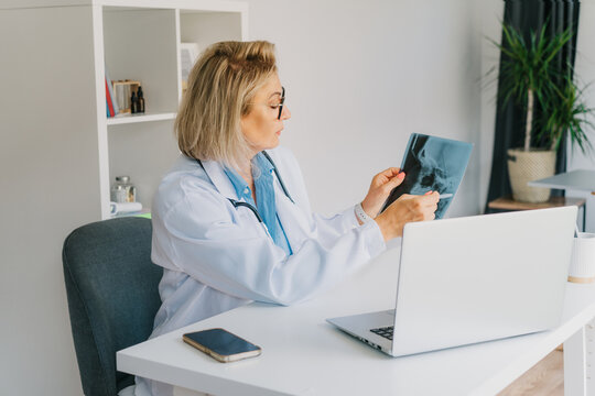 Female doctor makes online video call consult patient on laptop. Middle aged woman therapist videoconferencing for domestic health treatment. Telemedicine concept. Online remote medical appointment