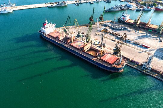 Aerial view from a drone of a large ship loading grain for export. Water transport