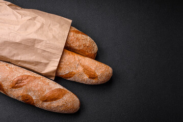French baguette bread on a dark textured concrete background