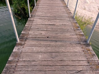 A beautiful wooden bridge over the water. Path over water. Pedestrian crossing over a water obstacle.
