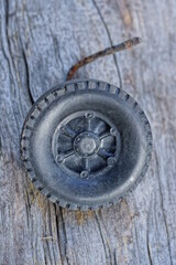one old small black wheel from a toy lies on a gray table