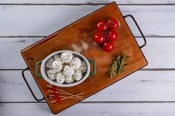 bowl with buffalo mozzarella balls and cherry tomatoes on the side