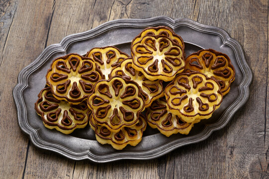 chocolate-dipped rosette cookies ( rose flower ) on a pewter plate