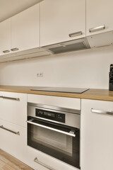 Fototapeta premium a kitchen with white cupboards and wood counter tops on the counters in this photo is taken from the inside