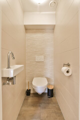 a bathroom with a toilet, sink and mirror on the wall next to it is a light fixture in the ceiling