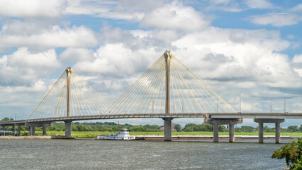 towboat with barges os passing under the Clark Bridge, a cable-stayed bridge across the Mississippi...