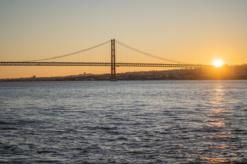 Sunset view over lisbon and 25 de Abril Bridge famous tourist landmark connecting Lisbon and Almada over Tagus river