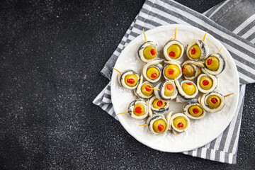 olives stuffed with anchovy fillets, anchovy rolls stuffed olives apetizing seafood pickled fish marinated ready to eat appetizer meal food snack on the table copy space food background rustic top