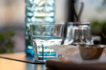Cold fresh water in old-fashioned bottle with glasses on a cafe table