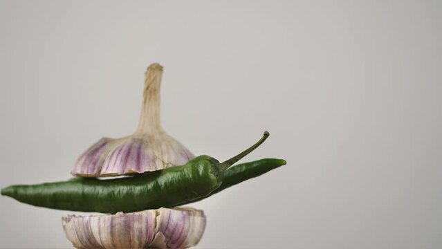 rotating young garlic with hot pepper inside on a white background.Copy space. place for text.
