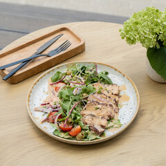 A plate with meat salad from veal on a wooden table